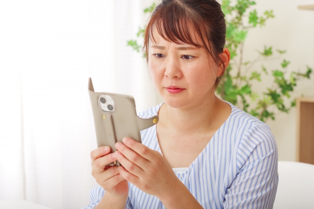 スマホを見ている60代女性