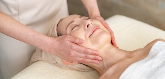 顔のリンパマッサージを受けている60代女性