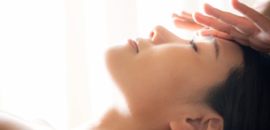 フェイシャルマッサージを受けている50代の女性