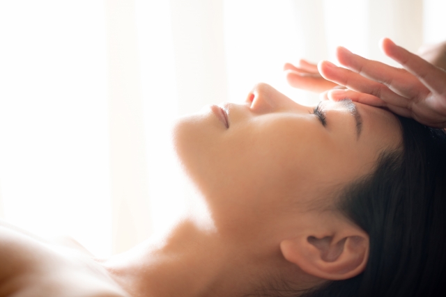 フェイシャルマッサージを受けている50代の女性