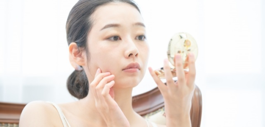 鏡を見ている50代の女性