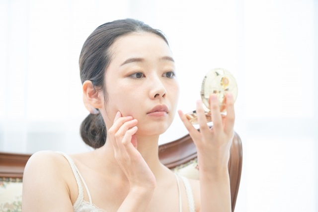 鏡を見ている50代の女性